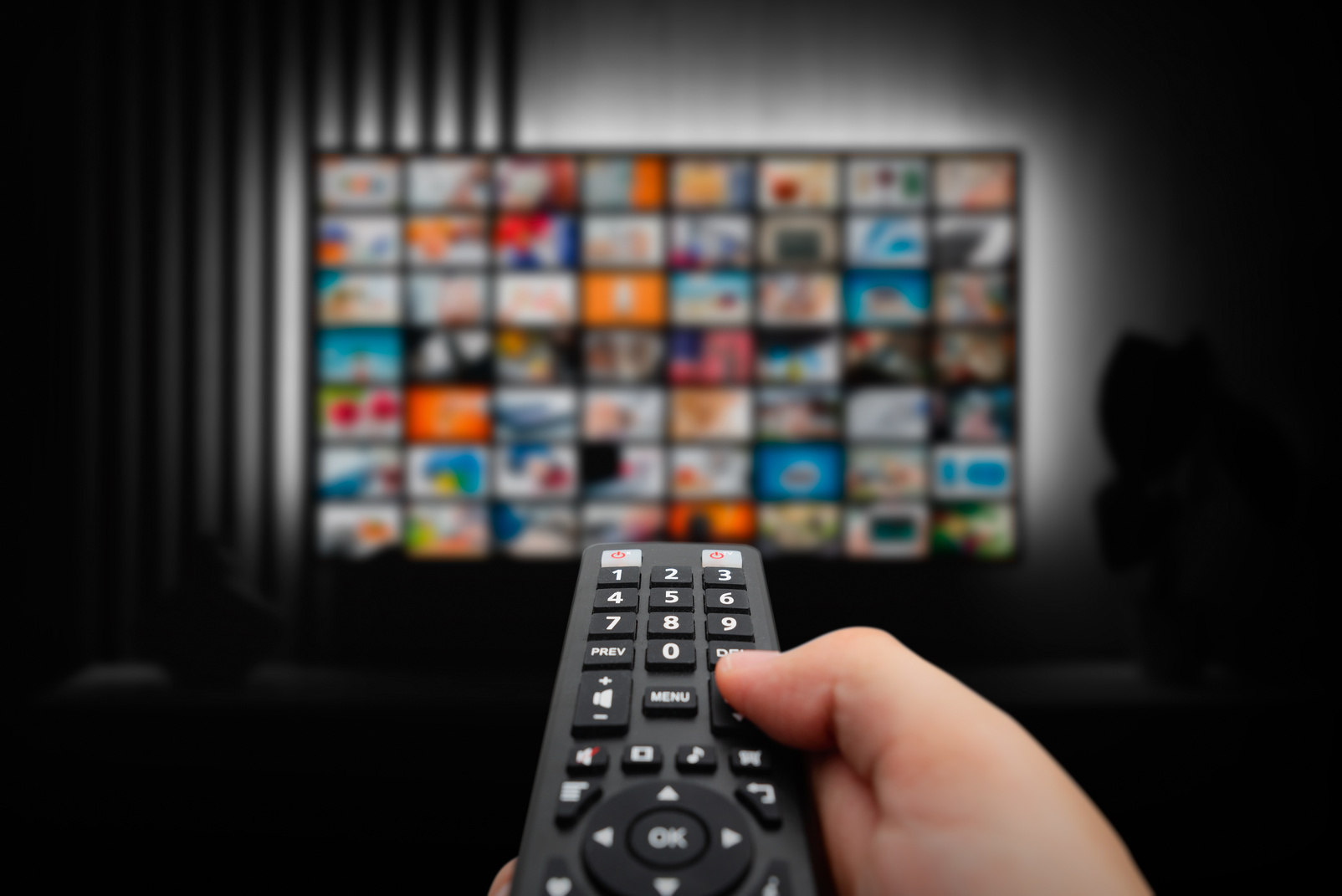 Man Watching TV with Remote Control in Hand.